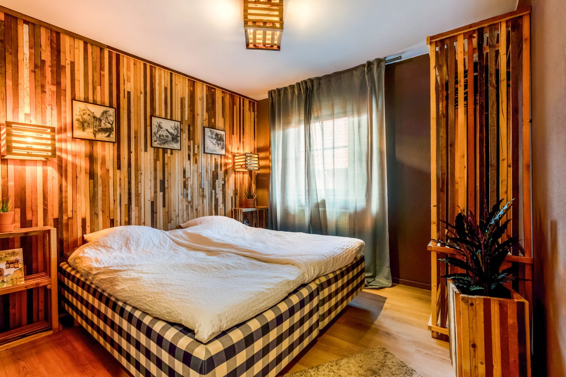 Slaapkamer met houten wandbekleding en tweepersoonsbed
